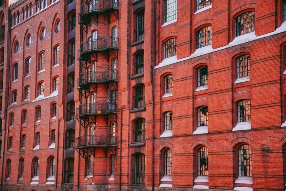A classic red brick facade featuring intricate architecture and iron balconies in Hamburg.