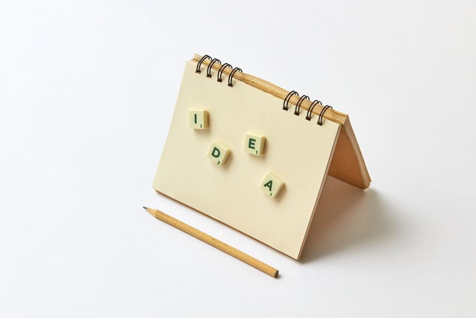Notebook with scrabble tiles spelling 'idea' and a pencil for creative inspiration.