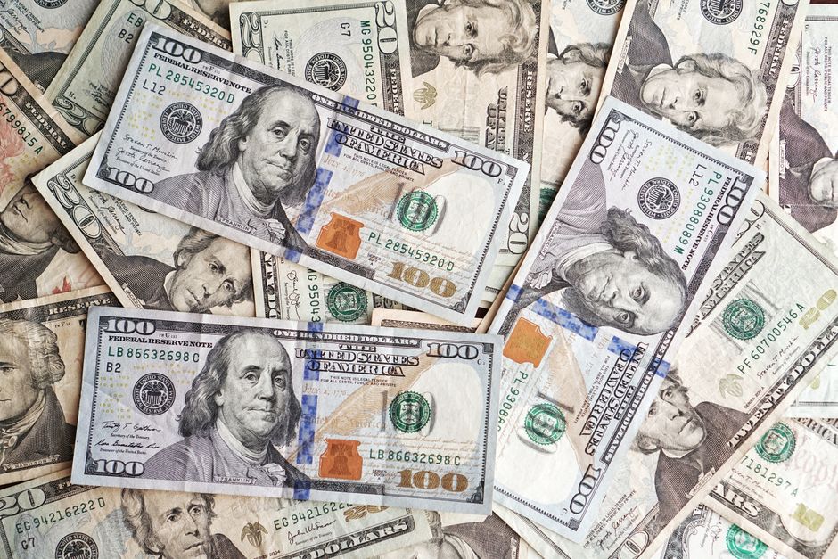 Close-up of various denominations of US dollar banknotes arranged in a pile representing finance and economics.